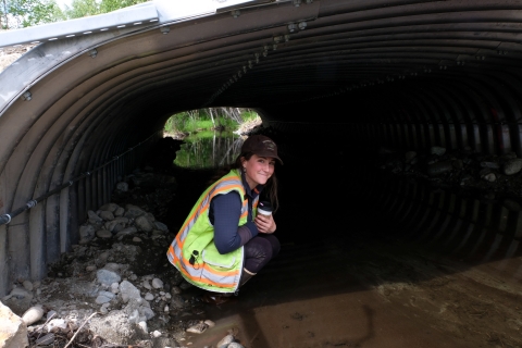 USFWS employee Jess Straub, underneath a culvert she helped design and implement in Wasilla, AK.
