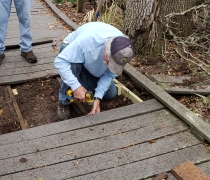 A refuge volunteer helps repair a boardwalk