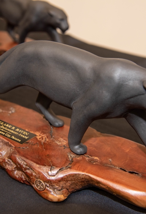 A statuette of a jaguar on a wooden pase