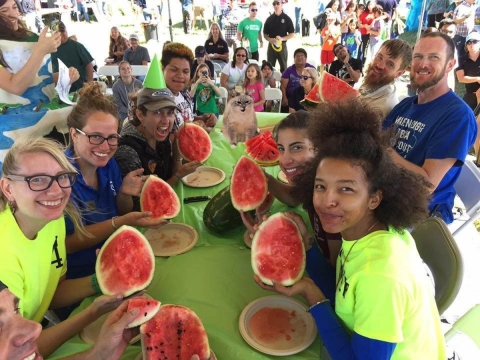 Eight participants in a watermelon-eating contest take a break from watermelon eating to smile for the camera.