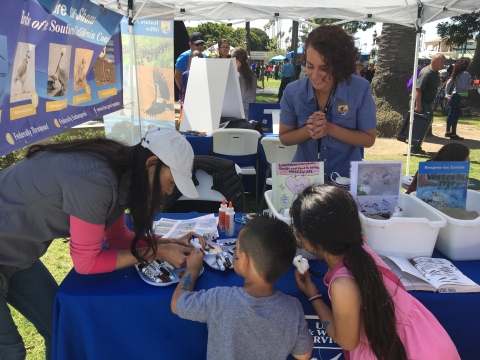 USFWS staff talk to kids at an outdoor community event