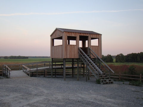 A viewing tower with a sunset in the background.