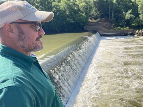 U.S. Fish and Wildlife Regional Director Leopoldo Miranda-Castro stands beside the dam.