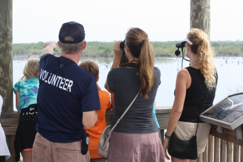 A volunteer helping visitors view birds.