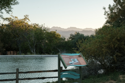 Small pond with interpretive sign. Mountains seen in distance.