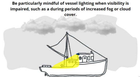 An ocean vessel is travelling through fog and high cloud cover with lights illuminating the deck. Text on the image reads "Be particularly mindful of vessel lighting when visibility is impaired, such as during periods of increased fog or cloud cover.