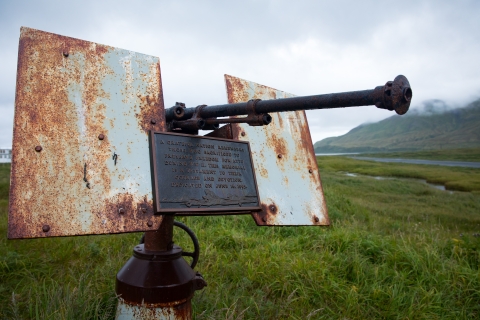 Rusted large gun with a plaque on the tundra
