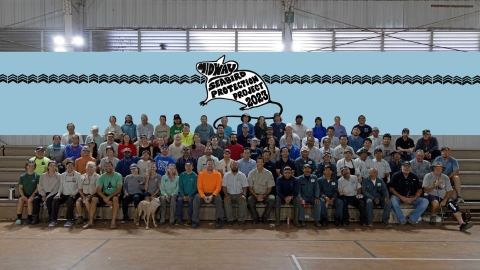 Group image of the seabird protection project team gathered at the Midway Atoll indoor basketball arena