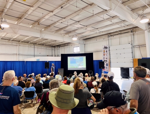 Pilot Biologist Brad Scotton presenting to a crowd at EAA AirVenture