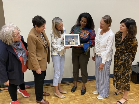 A group of six women admire the winning duck stamp artwork.