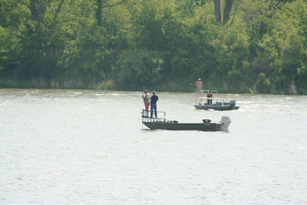 Two boats on the waters of DeSoto Lake with anglers fishing off them. 