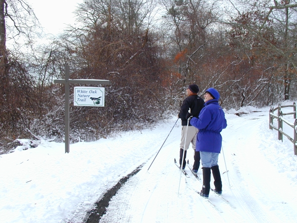 Man and woman cross country ski on the White Oak Trail