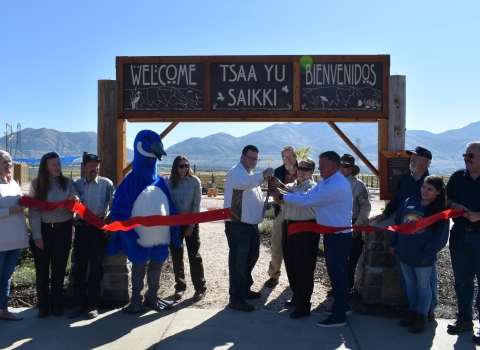 Grand opening ribbon cutting ceremony with officials from USFWS, Box Elder County, Box Elder County Tourism and Friends of the Bear River Refuge. Cutting ceremony in front of of the welcome sign with a mountain background