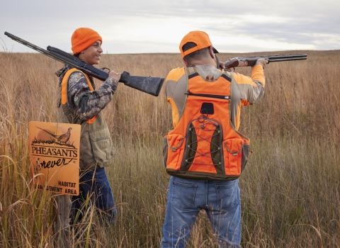 Father and son in hunter blaze orange vests.