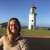 woman wearing USFWS uniform stands near a lighthouse