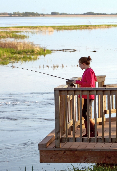A young woman fishing from a platform