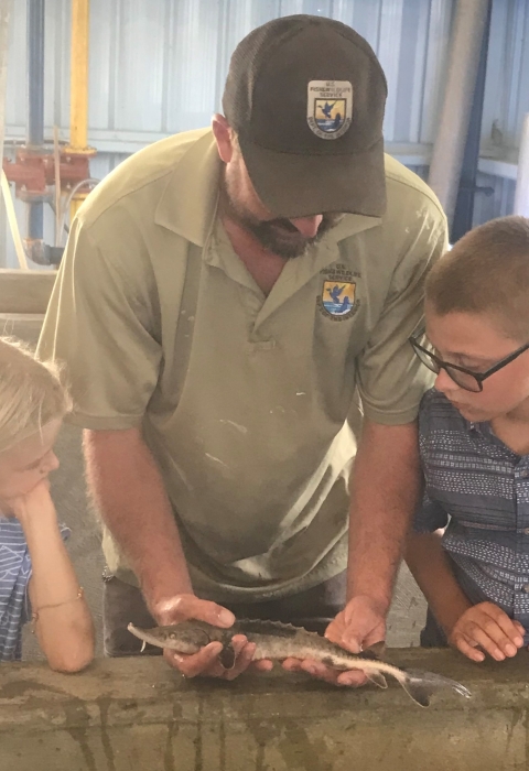 juvenile Lake Sturgeon raised at Edenton NFH with Deputy Manager and Children