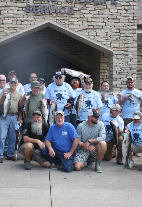 Wounded Warrior Fishing Derby participants holding stripers caught during the event