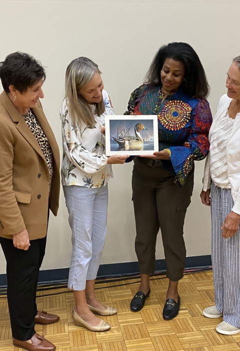 A group of six women admire the winning duck stamp artwork.