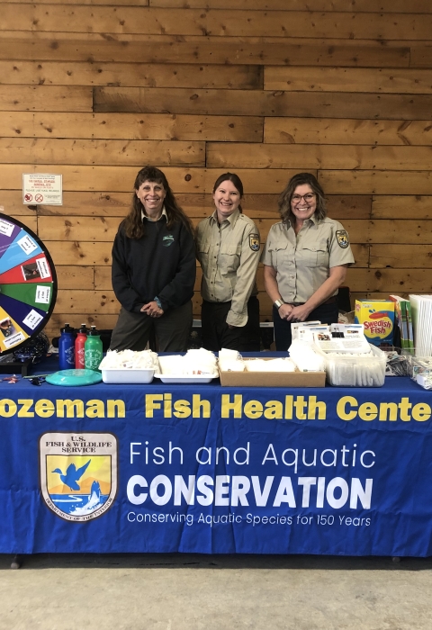 Biologists attend a table with education materials