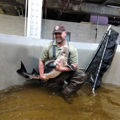 Man holding up sturgeon