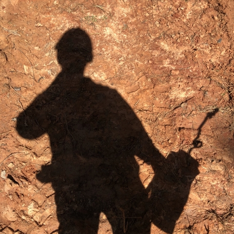 Silhouette of man holding fire equipment
