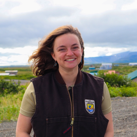 woman in front of a grassy area