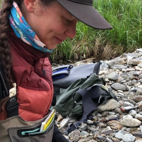 Woman wearing layered overalls, coat, neck gaitor and hat sets rat trip.