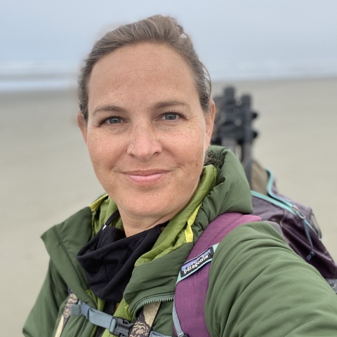 photo of Jenny on the beach with binoculars and spotting scope