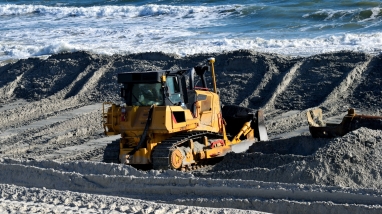 Bulldozer moving sand on a beach