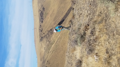 A woman walks on a hill