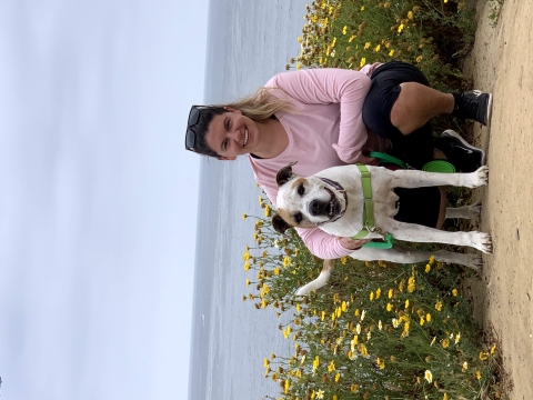 Sandra with her dog near yellow flowers