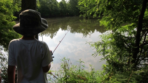 Boy with fishing pole at pond