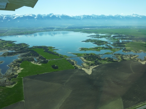 Arial view flying over Pablo Wildlife Refuge with the Mission Mountain Range in the background
