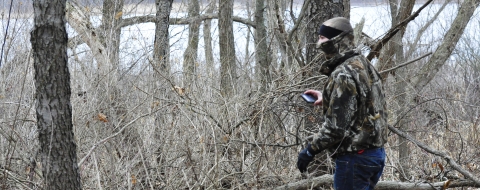 Photo of a young man earthcaching in a wooded area