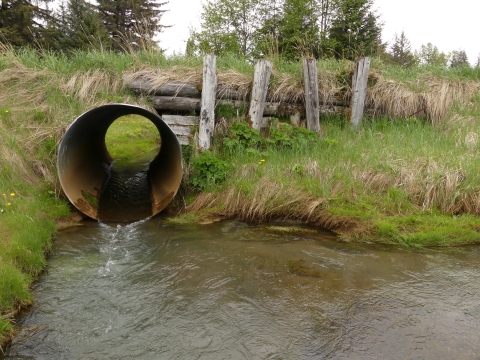a round culvert with a wooden embankment