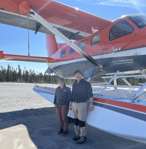 two people standing in front of an airplane