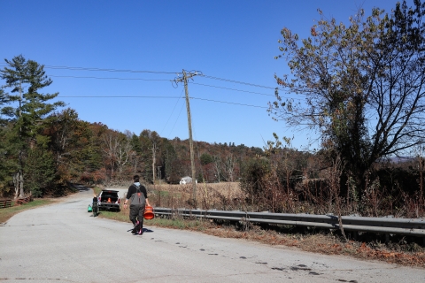 Two people, wearing wader, walking down a road