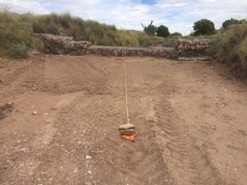 Intersecting yellow string on a dirt field