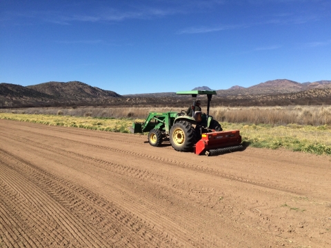 A vehicle seeds grass on a field