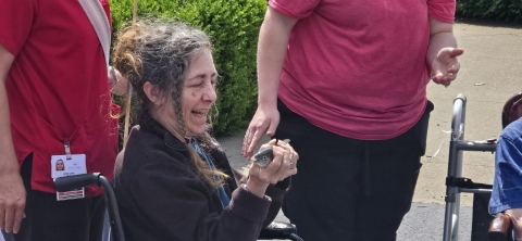Woman in wheelchair holding fish