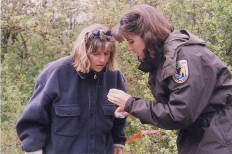 Two women look closely at something one of the is holding in her hand
