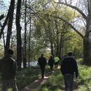 Group of people walking along stream.