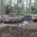 Image of construction taking place on a river side channel with a bulldozer