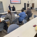 People listening to presenter in classroom