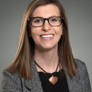 A women with glasses and short brown hair smiling