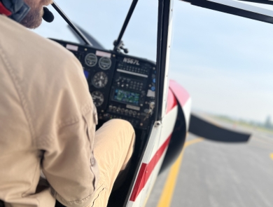Close Up of Federal Wildlife Officer/Pilot taxis at an airport with the entry window/door open.