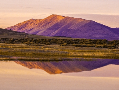 A mountain with grasslands and a wetland at Lower Klamath National Wildlife Refuge during sunset