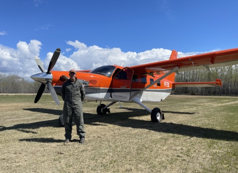 person stands in front of an airplane