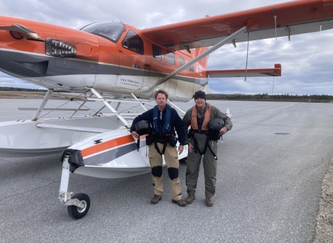 two people stand in front of an airplane